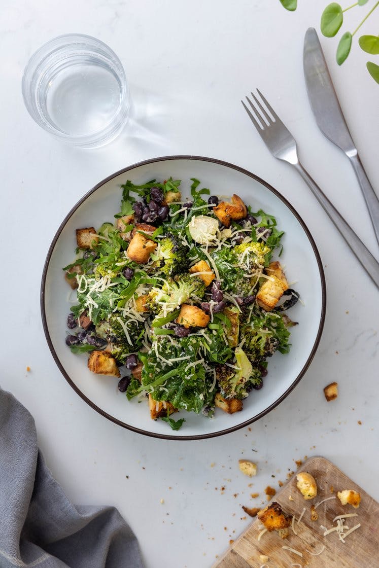 Kremet brokkolisalat med grønnkål og cashewdressing, toppet med hvitløkskrutonger 